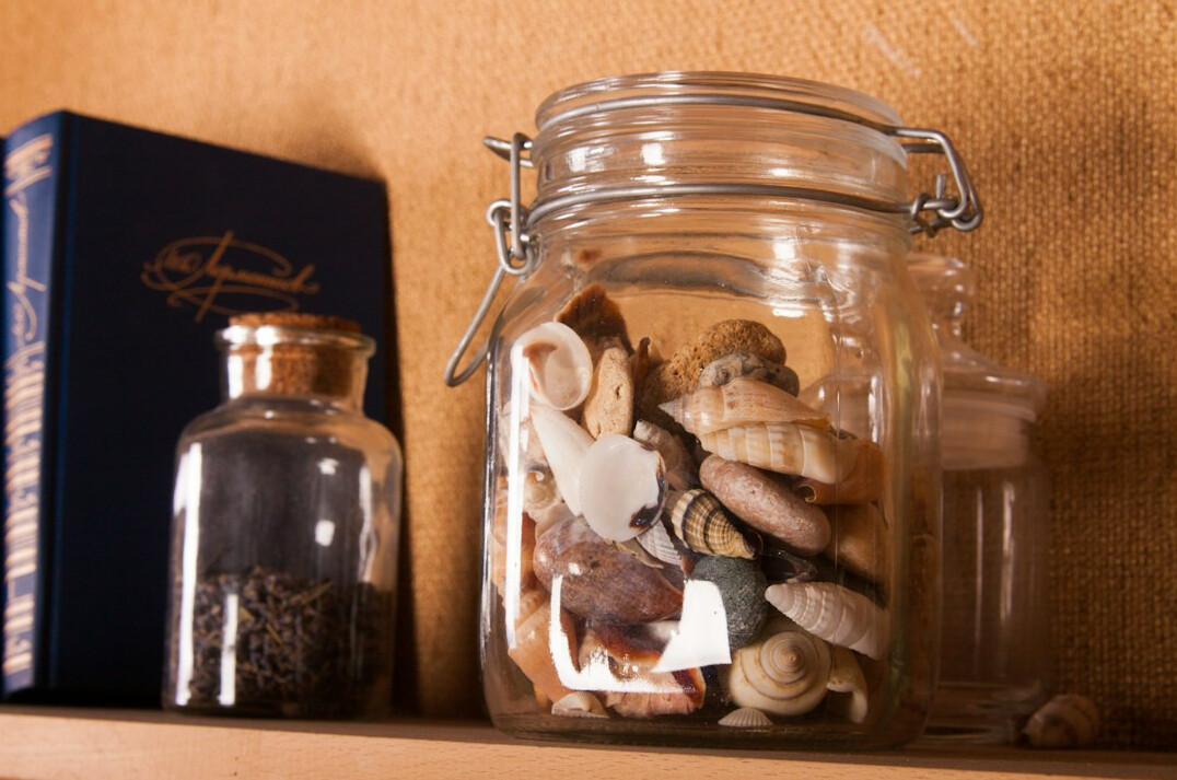 Glass jar filled with coins next to a notebook