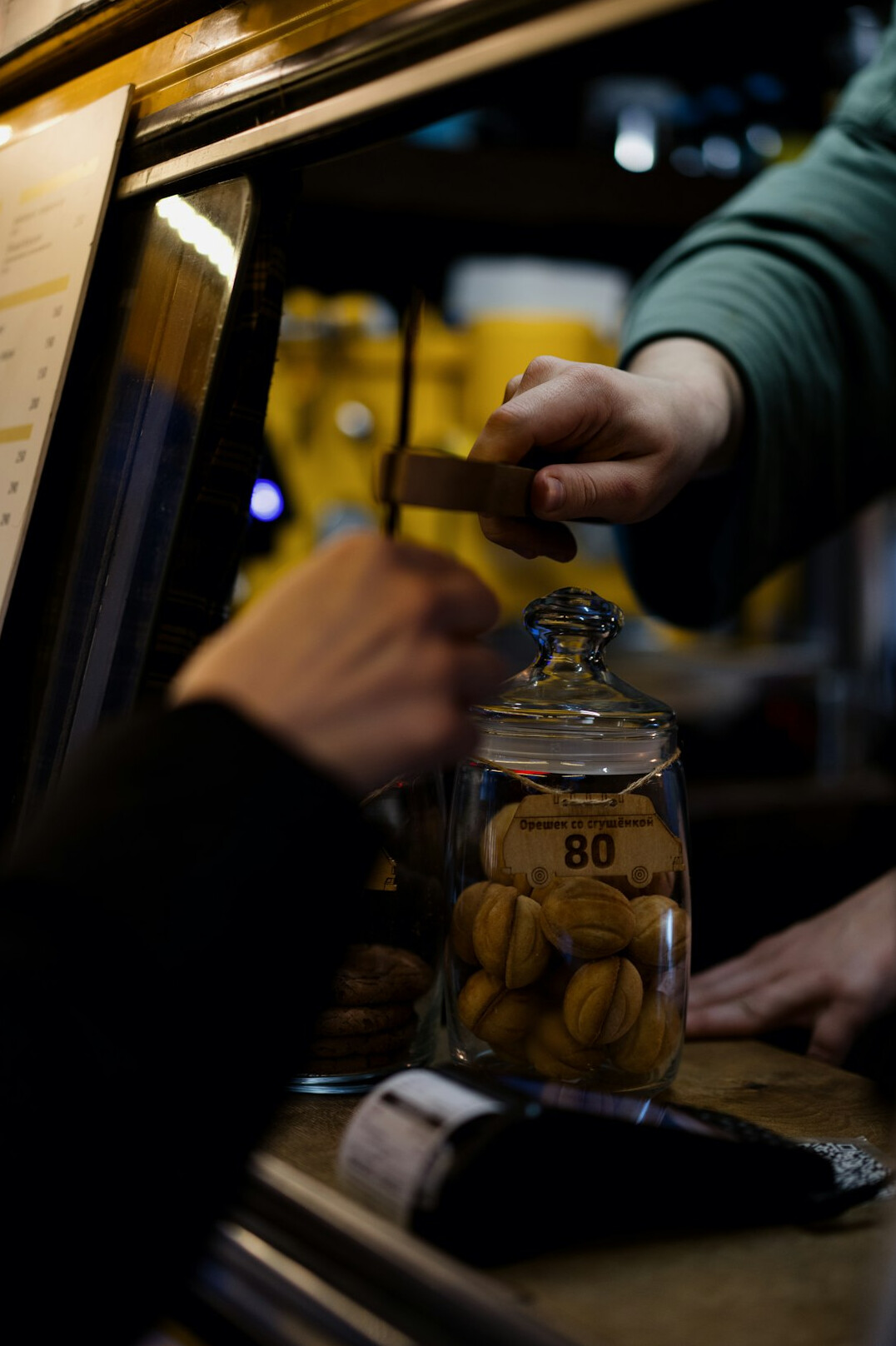 Hand putting coins into a jar as savings